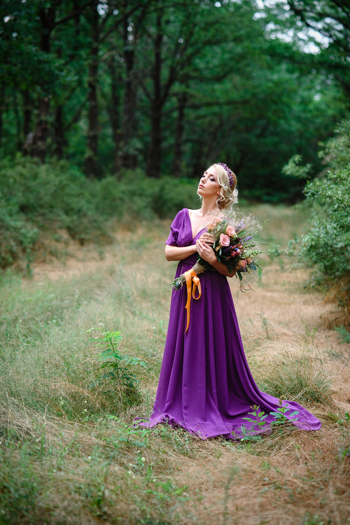 Girl Model Blonde in a Lilac Dress with a Bouquet